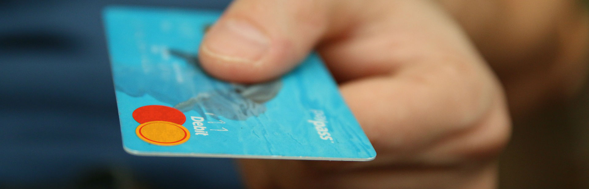 A hand holding a credit card