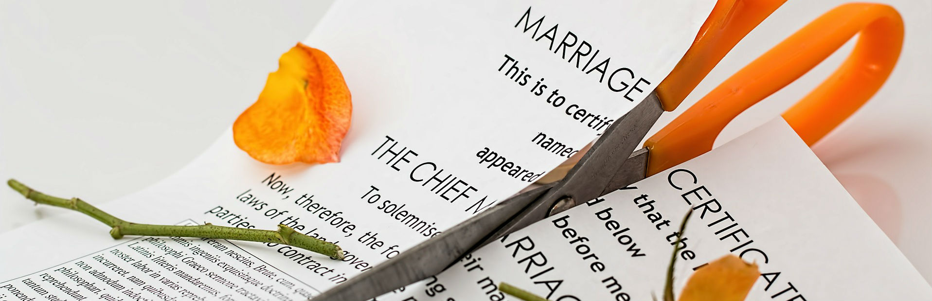 A pair of scissors resting on a marriage certificate